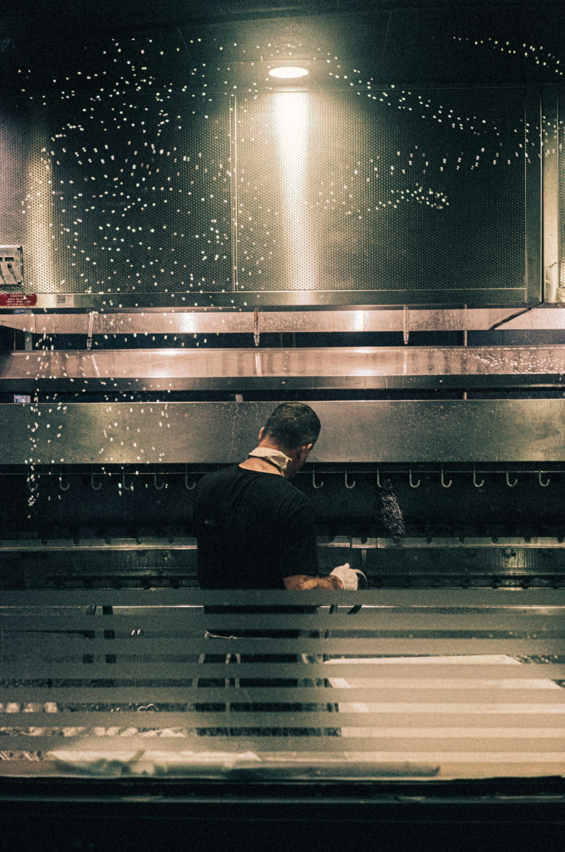 A man standing in front of a machine in a kitchen