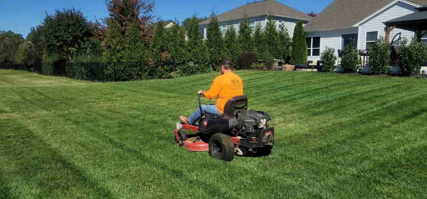 Person mowing a green lawn